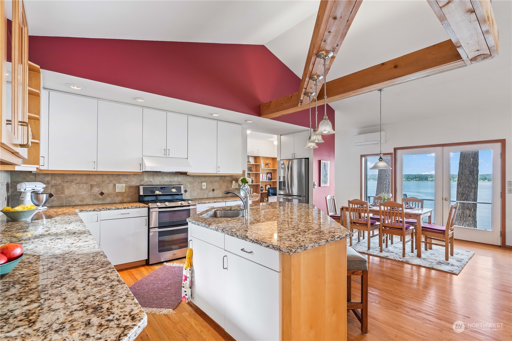 8615 Higgins Cove Road Anderson Island, WA 98303 - Photo 14 of 40 a kitchen with stainless steel appliances granite countertop a stove and white cabinets with wooden floor