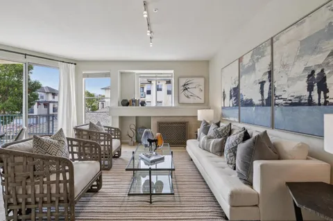 a living room with furniture a fireplace and a large window