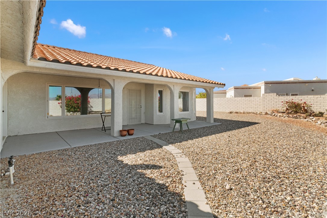 2055 Cholla Way Laughlin, NV 89029 - Photo 53 of 87 A terracotta-tiled roof crowns this residence, featuring a covered patio leading to a gravel yard with a stone path.