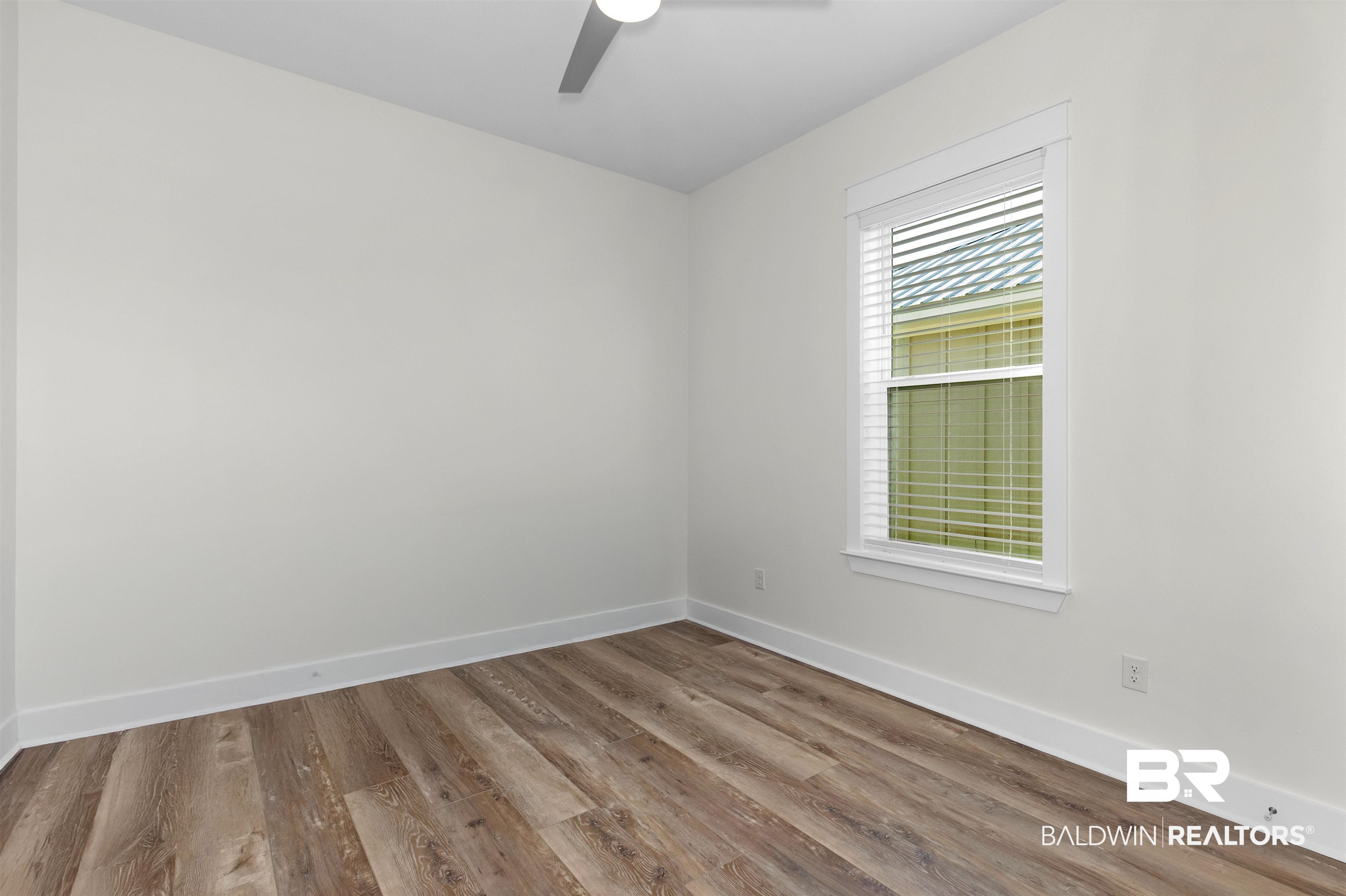 8069 Carmel Circle Foley, AL 36535 - Photo 11 of 23 Unfurnished room featuring a ceiling fan, baseboards, and wood finished floors