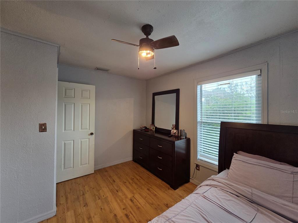 124 East F Street Frostproof, FL 33843 - Photo 16 of 37 a bedroom with a bed and a chandelier