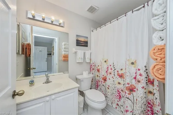 a bathroom with a sink and mirror with toilet