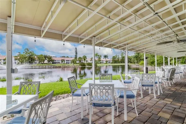 a view of a chairs and table in patio with swimming pool