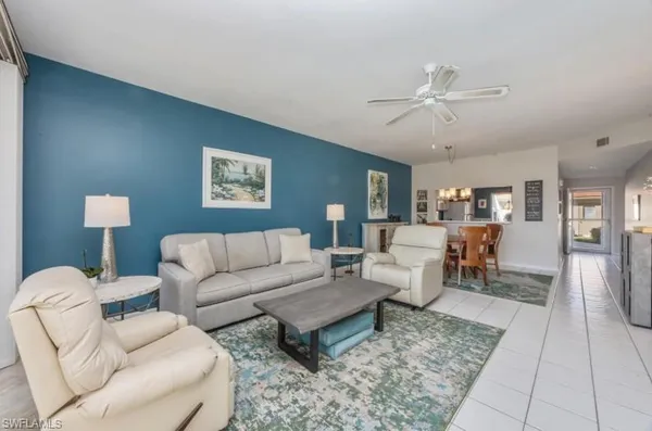 a living room with furniture a rug and a chandelier