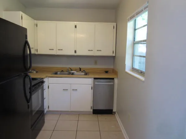 a kitchen with granite countertop white cabinets and stainless steel appliances