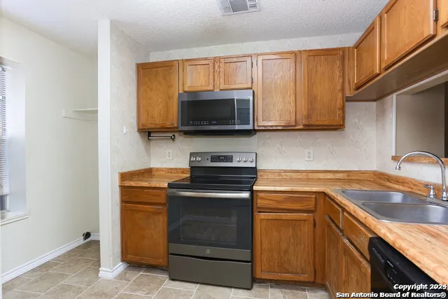 a kitchen with a sink stove and microwave