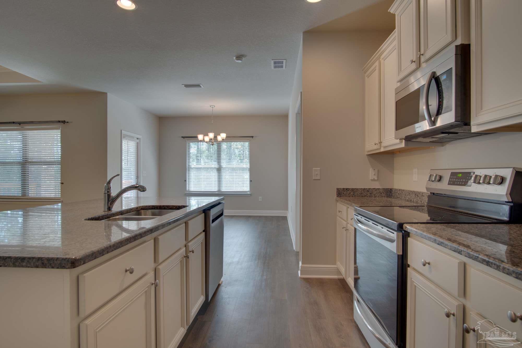 6239 Ladera Trail Pace, FL 32571 - Photo 8 of 27 a kitchen with stainless steel appliances granite countertop a sink and stove
