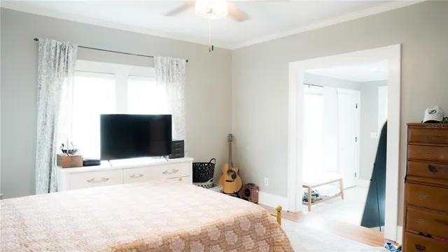 a bedroom with a bed and a flat tv screen on dresser