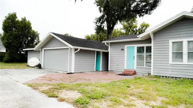 a front view of house with yard and trees in the background
