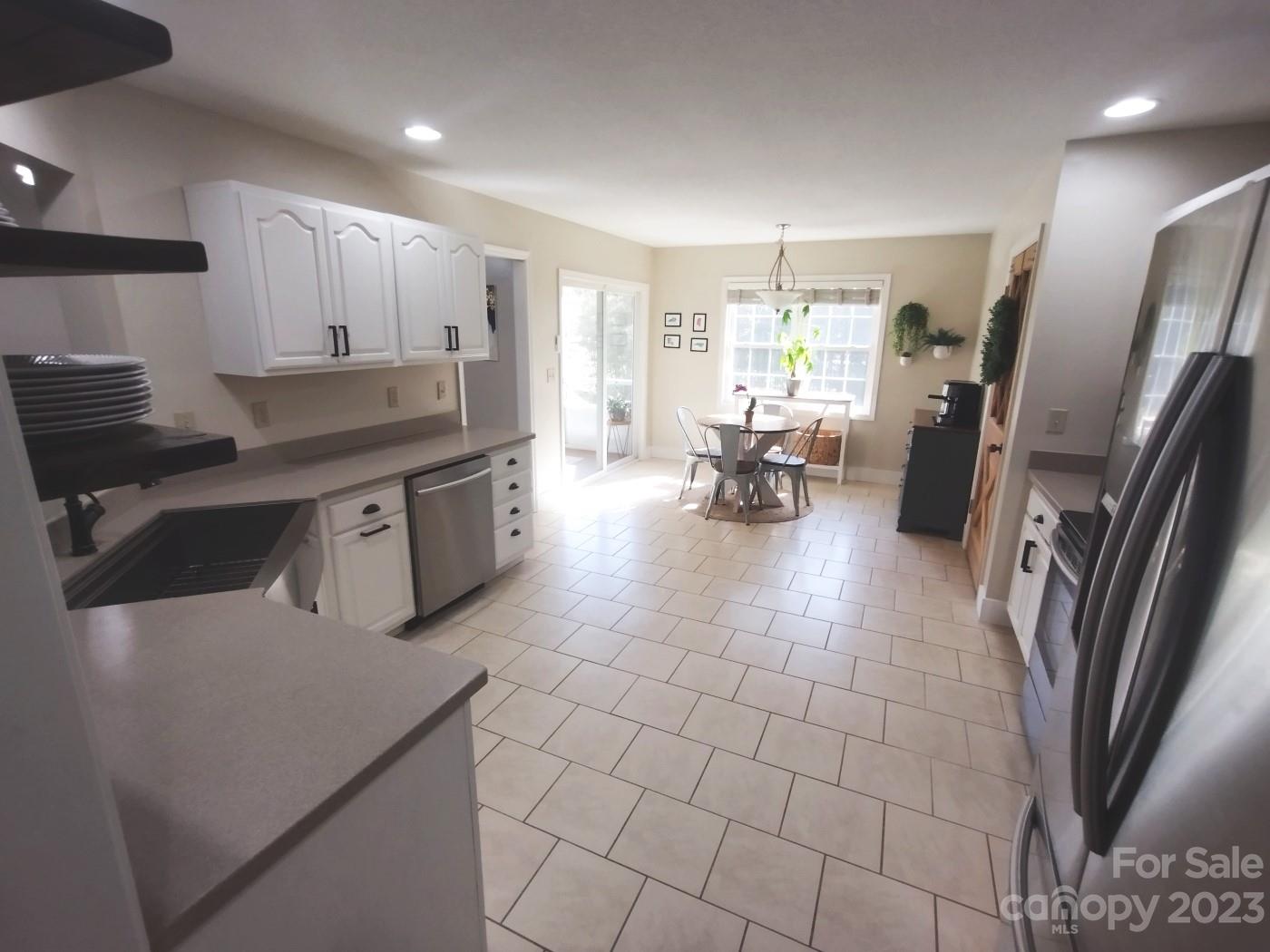80 South Sunset Ridge Drive Etowah, NC 28729 - Photo 15 of 48 a kitchen with stainless steel appliances a stove a sink a oven a refrigerator cabinets and dining table