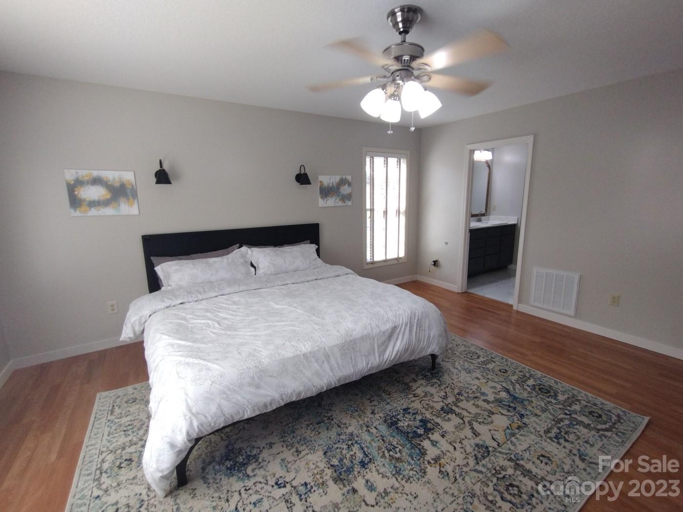 80 South Sunset Ridge Drive Etowah, NC 28729 - Photo 26 of 48 a bedroom with a large bed and a chandelier