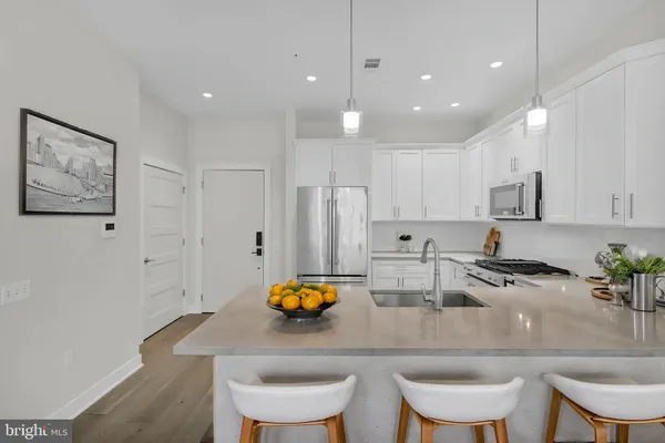 a kitchen with stainless steel appliances granite countertop a sink and a refrigerator