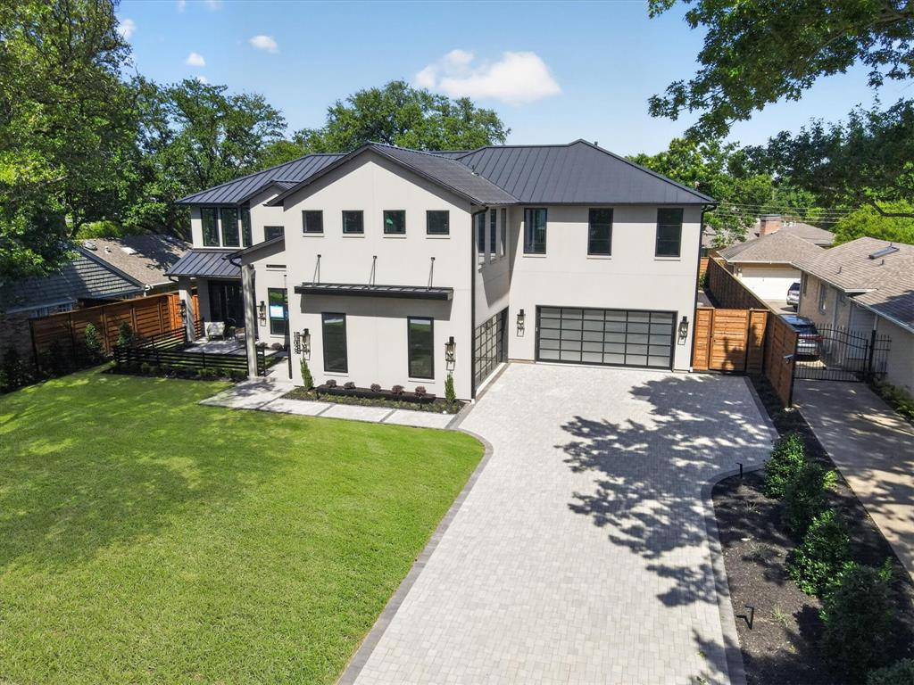 11028 Edgemere Road Dallas, TX 75230 - Photo 6 of 40 Modern contemporary residence featuring a light-colored stucco exterior, dark metal roof, and large format windows