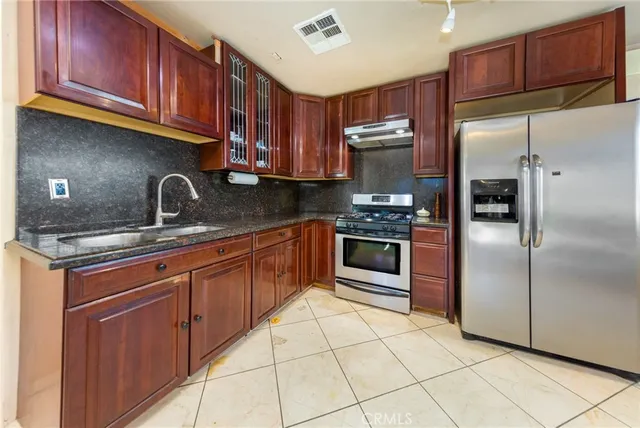 a kitchen with stainless steel appliances granite countertop a refrigerator sink and cabinets