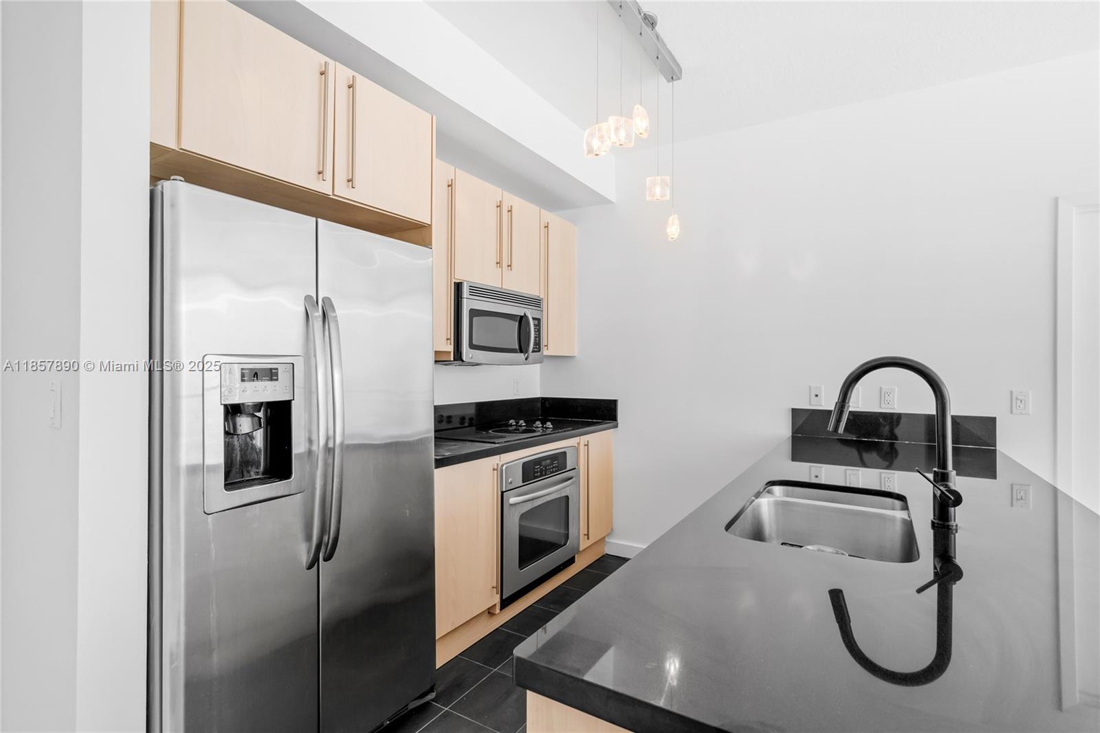 1111 Southwest 1st Avenue, Unit 2222N Miami, FL 33130 - Photo 14 of 53 a kitchen with stainless steel appliances granite countertop a refrigerator a stove and a sink with large mirror