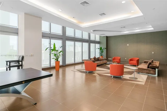 a living room with furniture a window and a flat screen tv