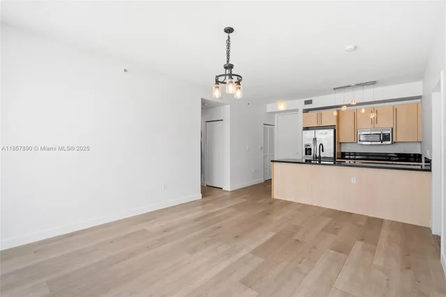 a view of a kitchen with a sink and dishwasher a refrigerator with wooden floor
