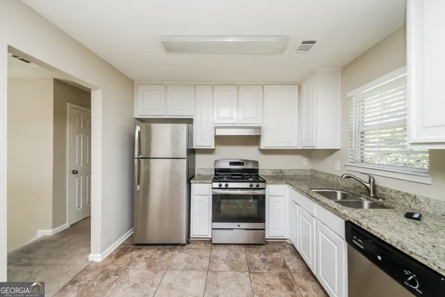 a kitchen with a sink stove and refrigerator