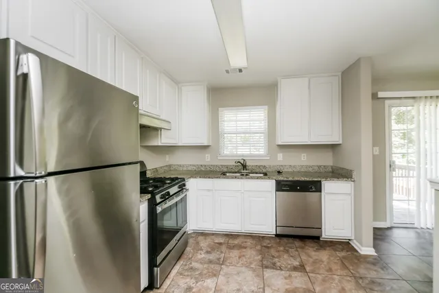 a kitchen with stainless steel appliances granite countertop white refrigerator a stove a sink and dishwasher