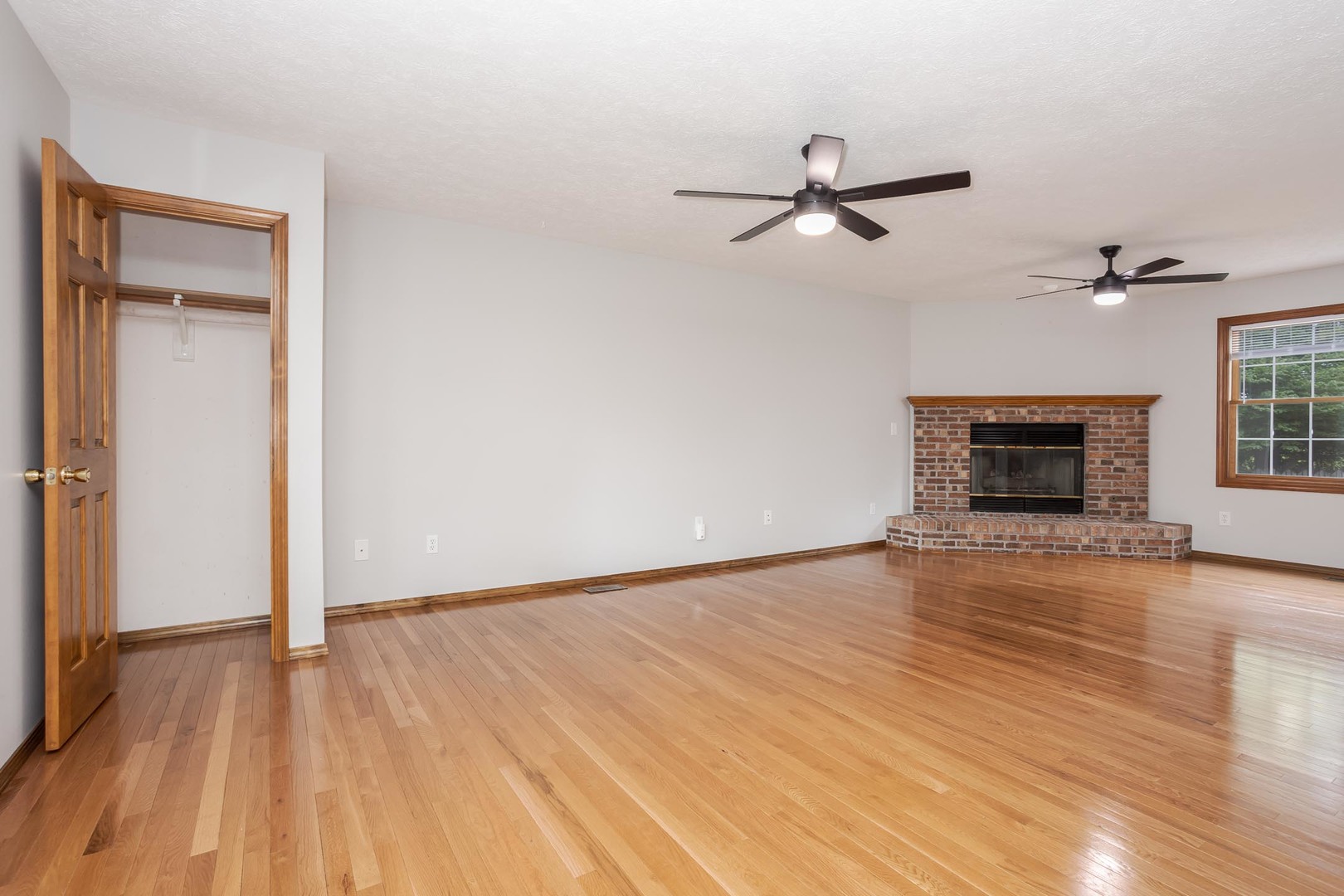 814 Landau Lane Normal, IL 61761 - Photo 14 of 58 an empty room with wooden floor a ceiling fan and windows