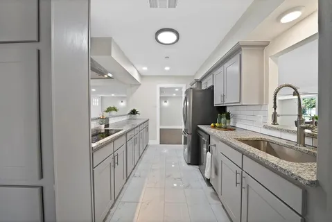 a kitchen with stainless steel appliances granite countertop a sink and cabinets