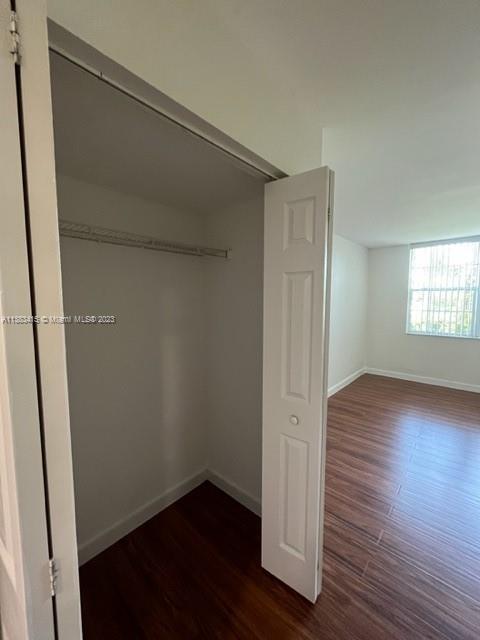 3299 Clint Moore Road, Unit 106 Boca Raton, FL 33496 - Photo 54 of 64 an empty room with wooden floor and windows