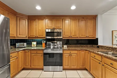 a kitchen with stainless steel appliances granite countertop a stove a sink and a microwave