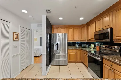 a kitchen with stainless steel appliances granite countertop a refrigerator and a sink