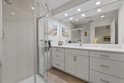 a bathroom with a double vanity sink mirror and shower