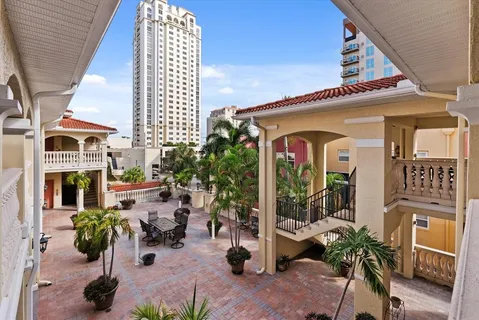 a view of a porch with chairs and potted plants