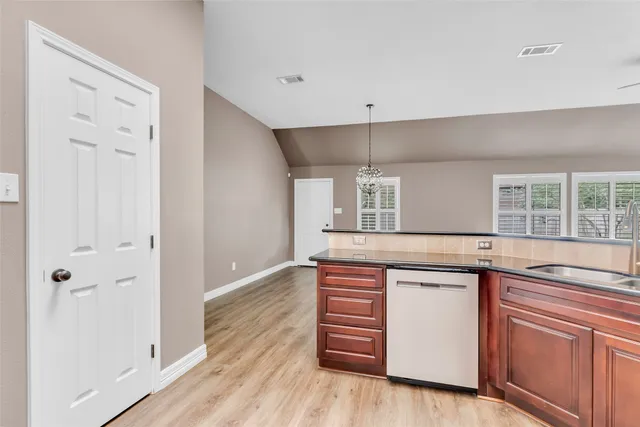 a kitchen with granite countertop a sink and wooden floor