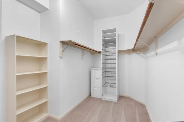 a view of walk in closet with empty racks