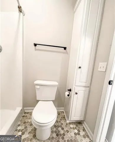 a bathroom with a toilet and a shower