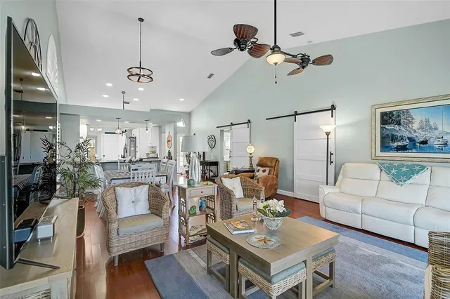 a living room with furniture kitchen view and a chandelier