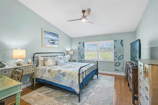 a bedroom with a bed and a flat tv screen on dresser