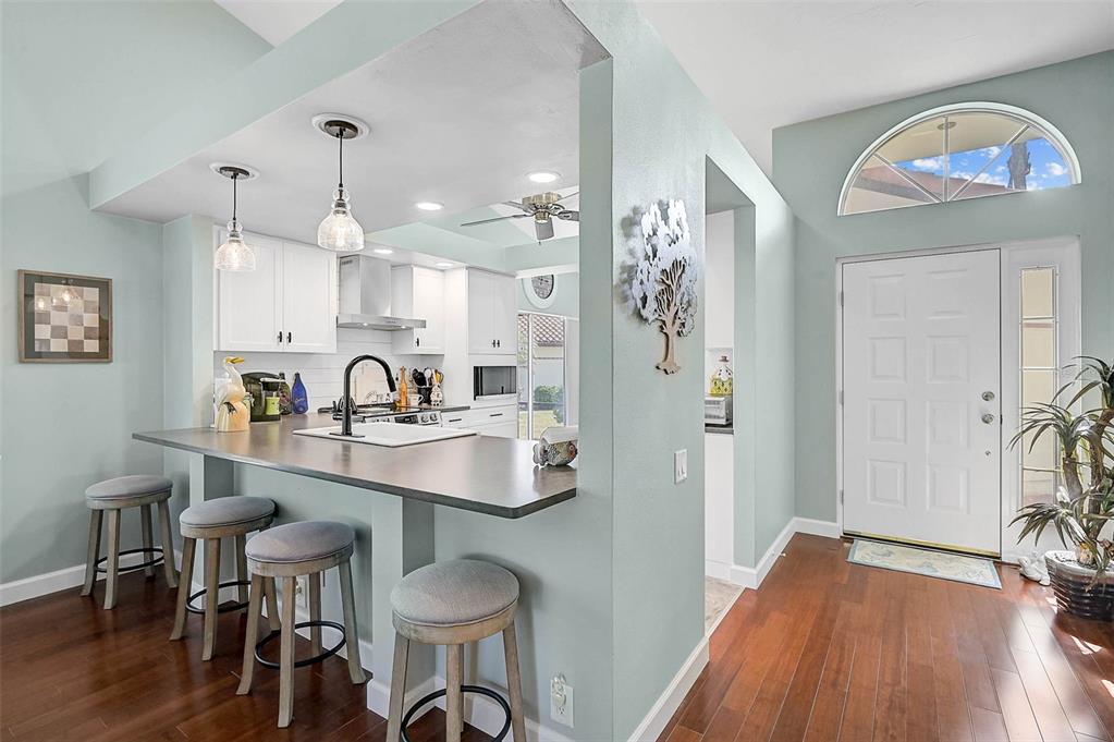 4934 Clubview Court East Bradenton, FL 34203 - Photo 2 of 44 a view of a kitchen area with wooden floor and furniture