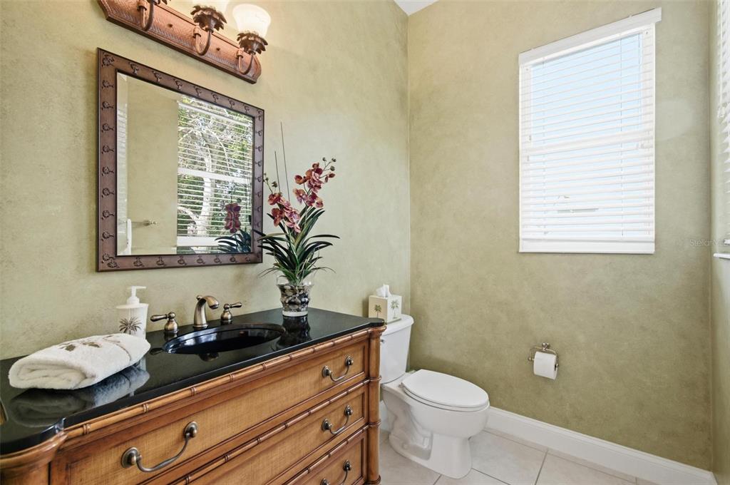 83 Front Street Palm Coast, FL 32137 - Photo 34 of 100 a bathroom with a granite countertop sink a large mirror and a toilet