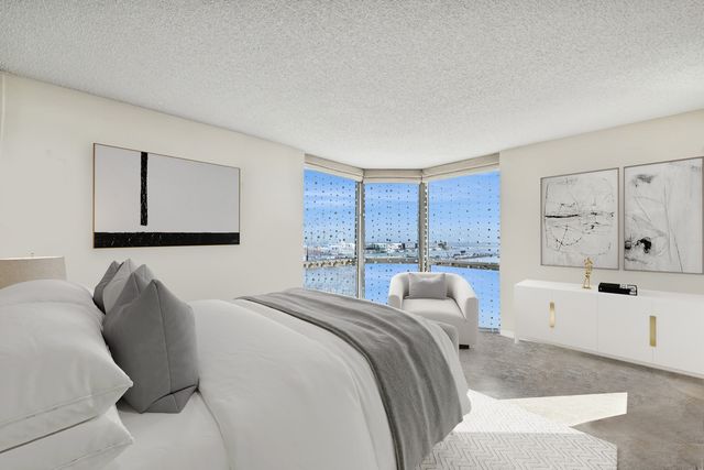 a living room with a large window and potted plant