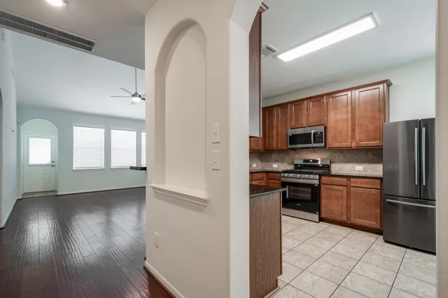 a kitchen with stainless steel appliances granite countertop a refrigerator stove top oven and sink