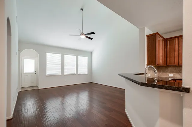 a kitchen with a sink a window and wooden floor