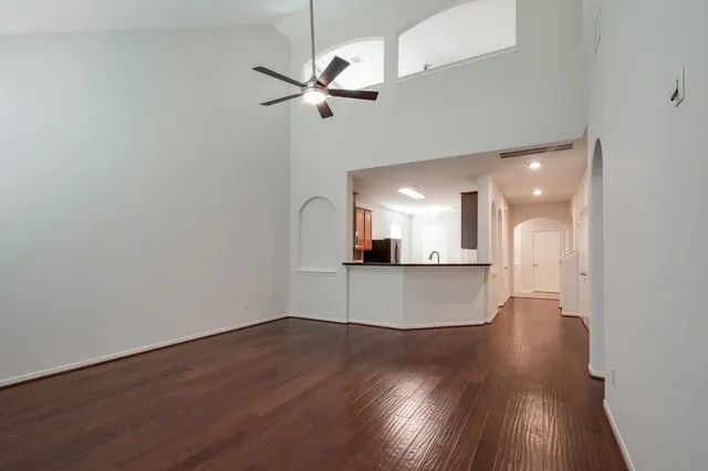 a view of a room with wooden floor and a ceiling fan