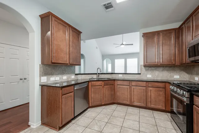 a kitchen with stainless steel appliances granite countertop a sink and cabinets