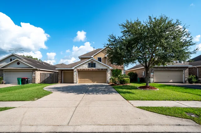 a front view of a house with yard and green space