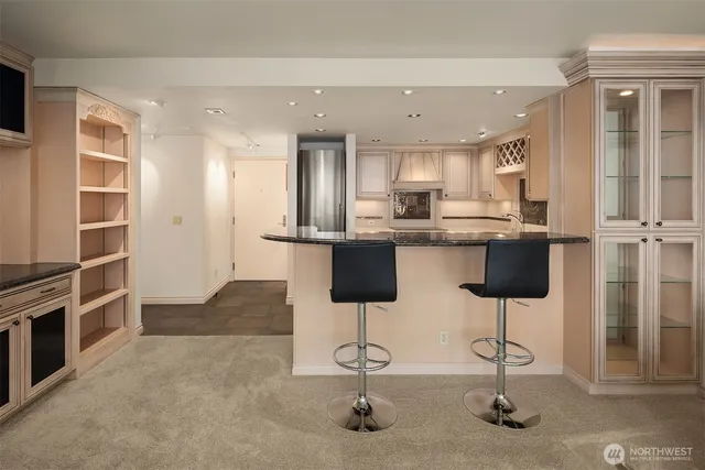 a kitchen with stainless steel appliances kitchen island granite countertop a refrigerator and cabinets
