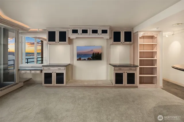 a living room with stainless steel appliances furniture and a kitchen view