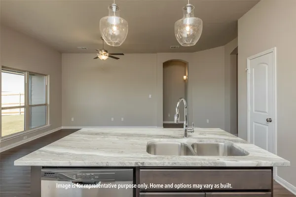 a kitchen with a sink a chandelier and a mirror