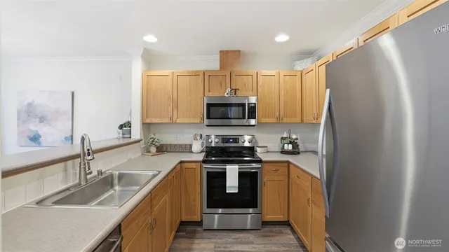 a kitchen with kitchen island granite countertop a sink stainless steel appliances and cabinets