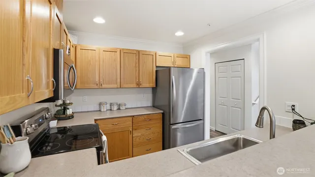 a kitchen with stainless steel appliances kitchen island a refrigerator sink and cabinets
