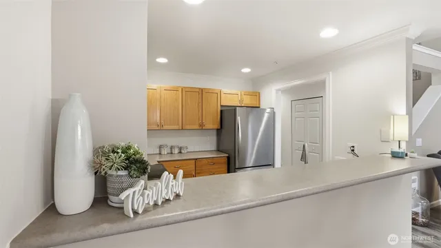 a kitchen with a potted plant and a refrigerator