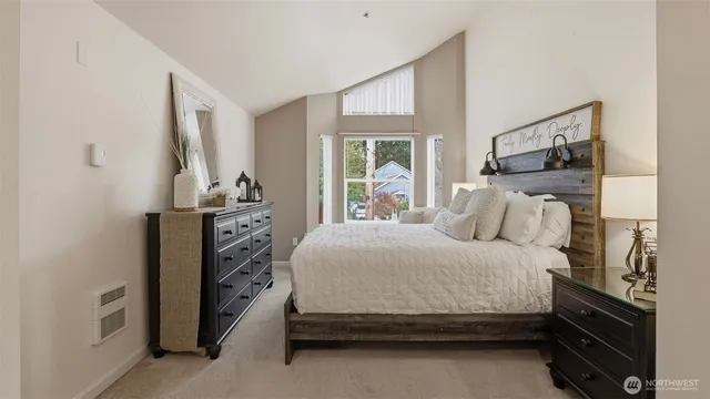 a bedroom with a bed and a flat tv screen on dresser